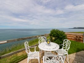 An outdoor seating area with a table and chairs at Clifftop Carriage in Aberporth, Ceredigion