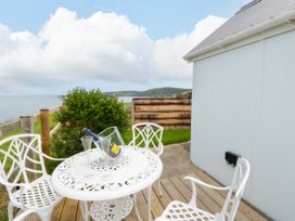 An outdoor seating area with a table and chairs at Clifftop Carriage in Aberporth, Ceredigion