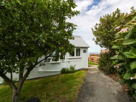 A pathway leading to a house with trees and bushes at Clifftop Carriage Aberporth, Ceredigion