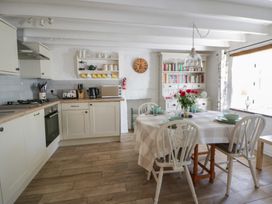 A kitchen with a dining table and shelves at End Cottage Newport, Pembrokeshire