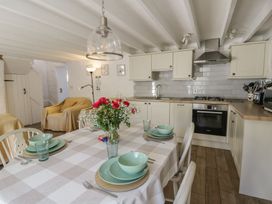 A kitchen with a dining table and stove at End Cottage in Newport, Pembrokeshire