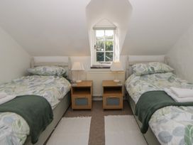 A bedroom with two beds and a window at End Cottage Newport, Pembrokeshire