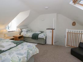 A bedroom with two beds and a nightstand at End Cottage in Newport, Pembrokeshire