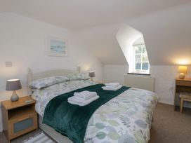 A bedroom with a bed and bedside tables at End Cottage in Newport, Pembrokeshire