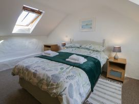A bedroom with a bed and nightstand at End Cottage Newport, Pembrokeshire