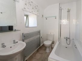 A bathroom with a bathtub, sink, toilet, and towel radiator at End Cottage Newport, Pembrokeshire