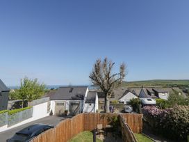 An outdoor area with a tree and parked cars at End Cottage in Newport, Pembrokeshire