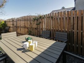 A garden with a table and chairs and mugs at End Cottage, Newport, Pembrokeshire