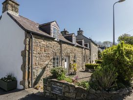A stone house with a garden and pathway at Pendre House and Cottages in Newport, Pembrokeshire