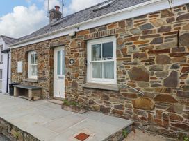A stone wall with a door and windows at Brynawelon Newport, Pembrokeshire