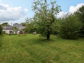 A garden with trees and benches at Brynawelon Newport, Pembrokeshire