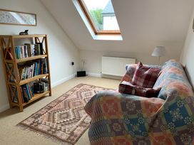 A snug with a bookshelf and sofa at Brynawelon in Newport, Pembrokeshire