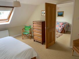 A bedroom with a bed and dresser at Brynawelon, Newport, Pembrokeshire