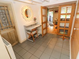 An entrance hall with a mirror and shelves at Greenbanks in Dinas Cross, Pembrokeshire