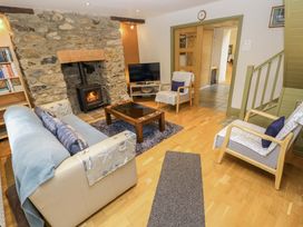 A living room with a fireplace and television at Greenbanks in Dinas Cross, Pembrokeshire