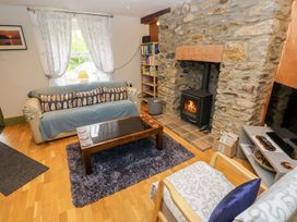A living room with a fireplace and sofa at Greenbanks in Dinas Cross, Pembrokeshire