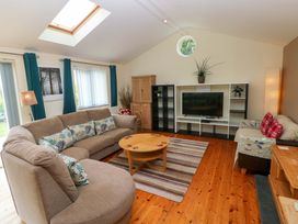 A living room with sofas and a television at Greenbanks in Dinas Cross, Pembrokeshire