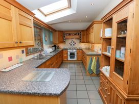 A kitchen with wooden cabinets and a countertop at Greenbanks, Dinas Cross, Pembrokeshire