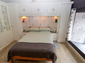 A bedroom with a bed and wardrobe at Greenbanks in Dinas Cross, Pembrokeshire