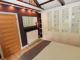 A bedroom with a wardrobe, mirror, and radiator at Greenbanks, Dinas Cross, Pembrokeshire