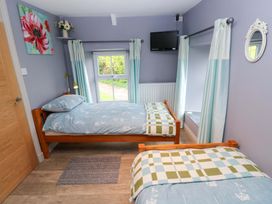 A bedroom with two beds and a television at Greenbanks in Dinas Cross, Pembrokeshire