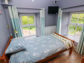 A bedroom with a bed and window at Greenbanks in Dinas Cross, Pembrokeshire