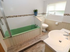 A bathroom with a bathtub, toilet, and sink at Greenbanks Dinas Cross, Pembrokeshire