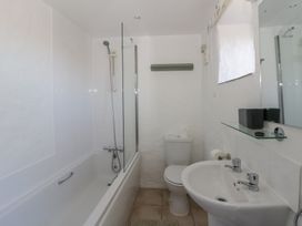 A bathroom with a bathtub, shower, toilet and sink at Middle Cottage Newport, Pembrokeshire