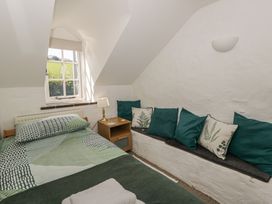 A bedroom with a bed and cushions at Middle Cottage in Newport, Pembrokeshire