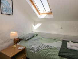 A bedroom with a bed and a lamp at Middle Cottage in Newport, Pembrokeshire