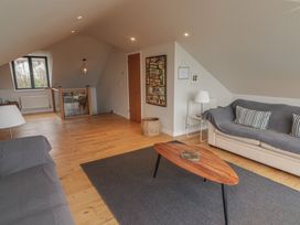 A living room with two sofas a wooden coffee table and a painting on the wall at The Willows in Newport Pembrokeshire