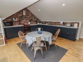 A kitchen with a round table and four chairs in the middle at The Willows in Newport Pembrokeshire