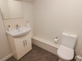 A bathroom with a sink cabinet mirror toilet and toilet paper holder at The Willows in Newport Pembrokeshire