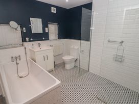 A bathroom with a bathtub sink toilet and walk in shower at The Willows in Newport Pembrokeshire