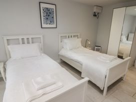 A bedroom with two single beds a bedside table and a wardrobe with mirrored doors at The Willows in Newport Pembrokeshire