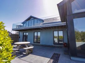 An outdoor area with a table and chairs beside a house at The Willows in Newport, Pembrokeshire