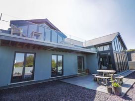 A house with a deck and outdoor table at The Willows in Newport, Pembrokeshire