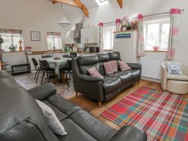 A living room with a sofa and dining area at Y Felin in Cardigan, Ceredigion