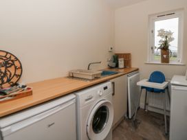 A laundry room with a washing machine and a counter at Y Felin in Cardigan, Ceredigion