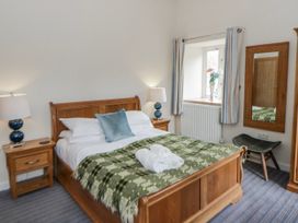 A bedroom with a bed and side tables at Y Felin in Cardigan, Ceredigion