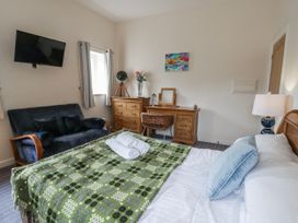 A bedroom with a bed and sofa at Y Felin in Cardigan, Ceredigion