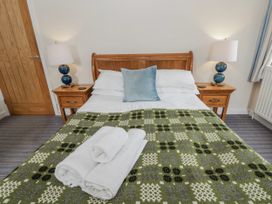 A bedroom with a bed and bedside tables at Y Felin in Cardigan, Ceredigion