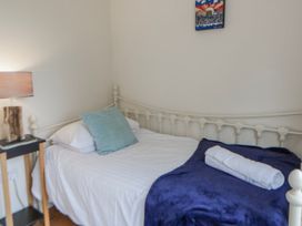A bedroom with a bed and lamp at Y Felin in Cardigan, Ceredigion