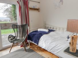 A bedroom with a bed and chair at Y Felin in Cardigan, Ceredigion