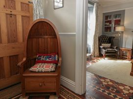 A hallway with a wooden door and a bench at Dewi Villa in Aberarth, Ceredigion