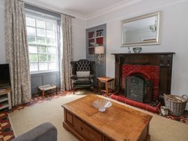 A living room with a fireplace and armchair at Dewi Villa in Aberarth, Ceredigion