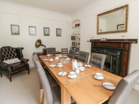 A dining room with a wooden table set for tea at Dewi Villa, Aberarth, Ceredigion
