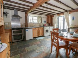 A kitchen with wooden cabinets and appliances at Dewi Villa in Aberarth, Ceredigion