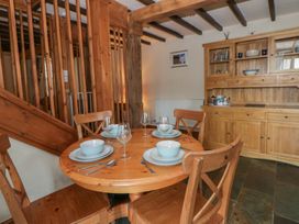 A dining room with a round table and chairs at Dewi Villa in Aberarth, Ceredigion