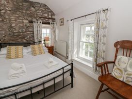 A bedroom with a bed and a chair at Dewi Villa in Aberarth, Ceredigion